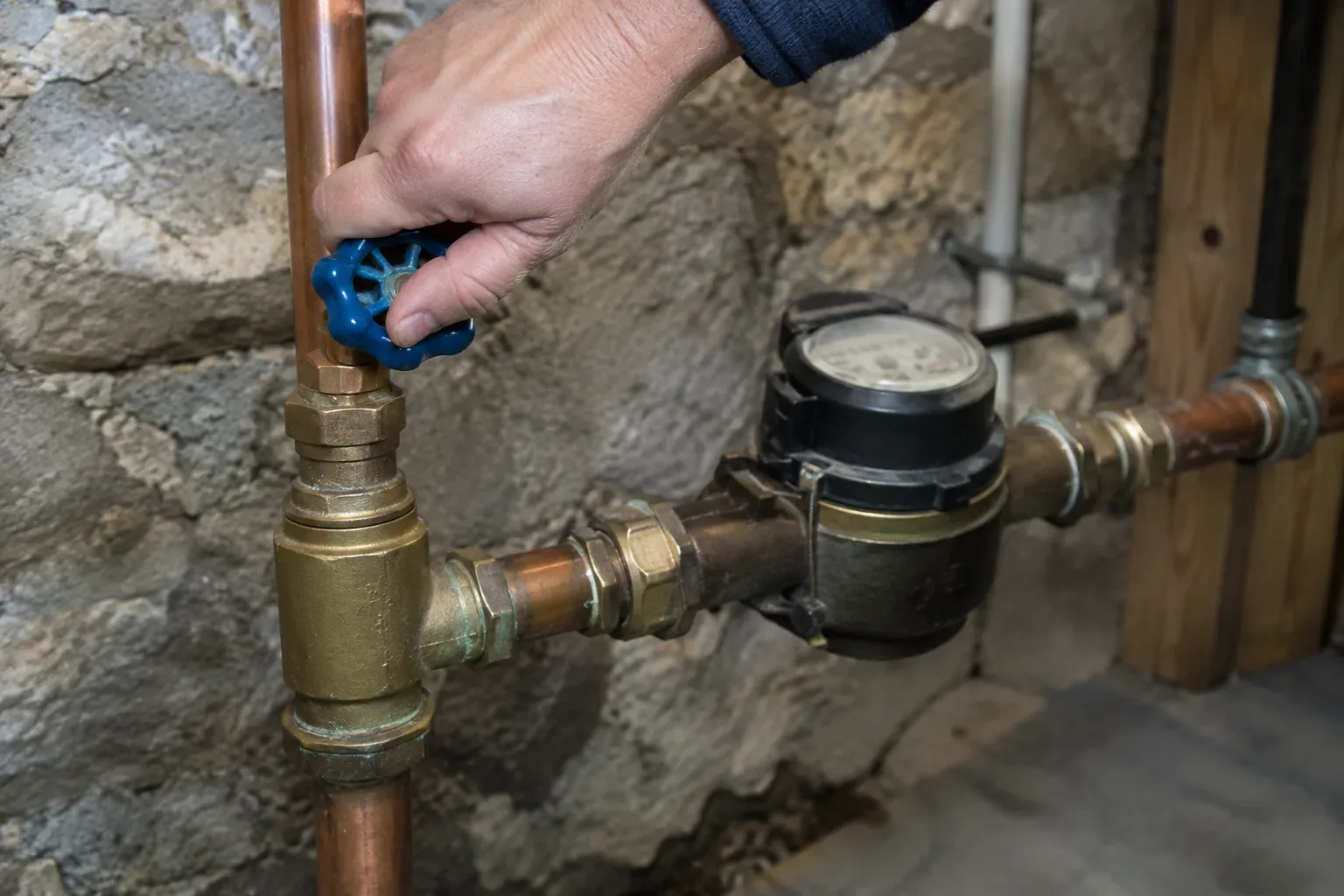 Homeowner locating the main water shutoff valve in a Greater Boston basement